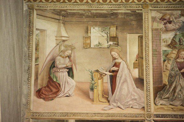 Die Verkündigung: Der Engel Gabriel kniet in einem Raum vor Maria. 