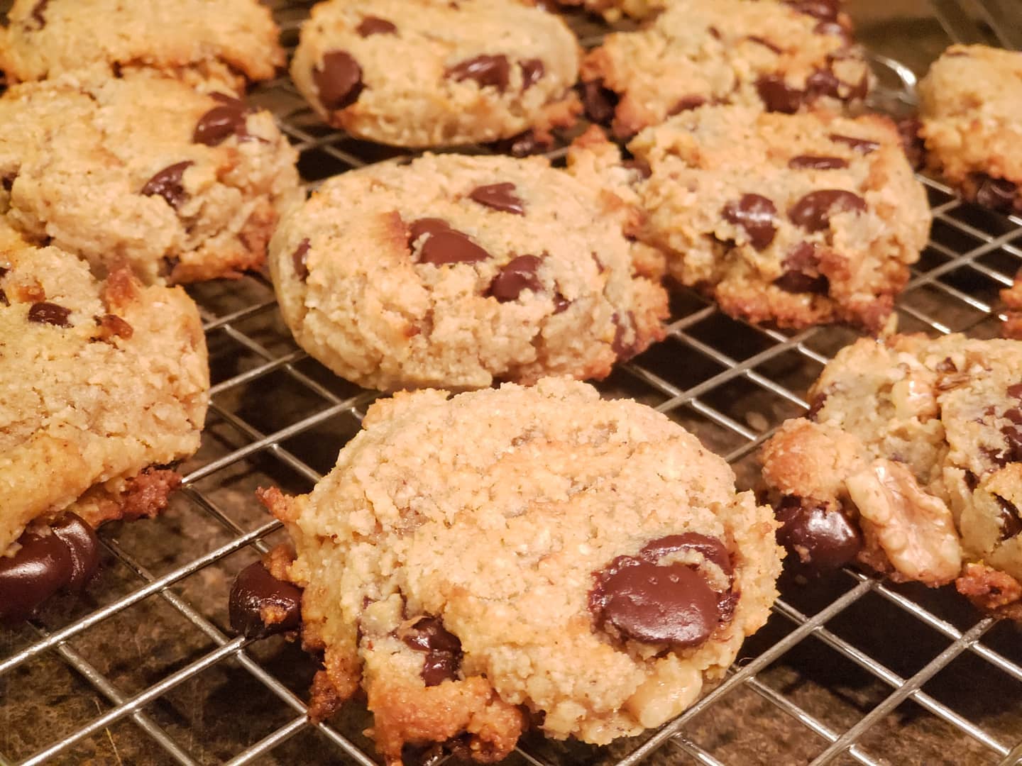 Chocolate chip cookies on a wire rack; some have melted chocolate visible.