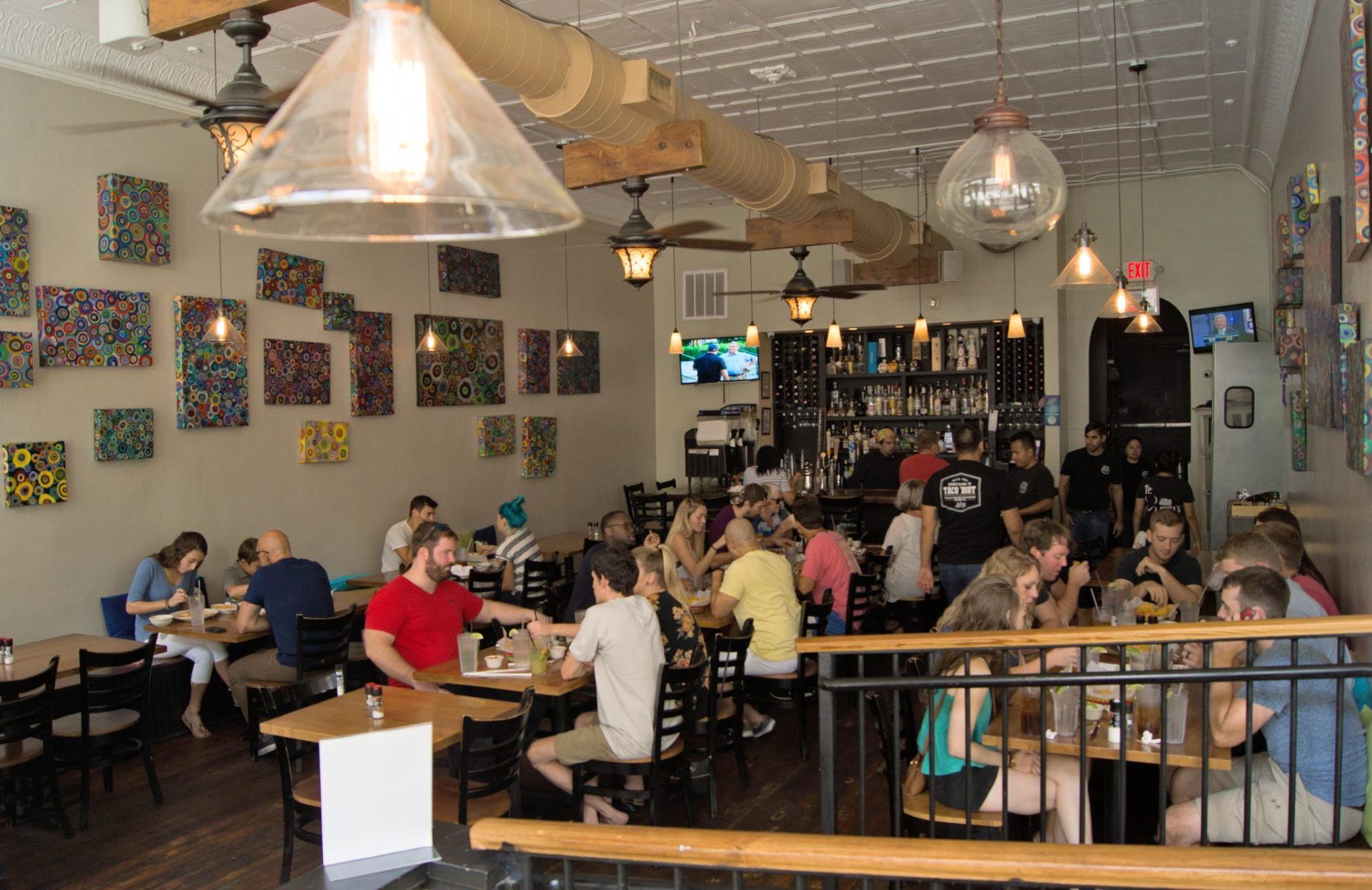 A group of people are sitting at tables in a restaurant.
