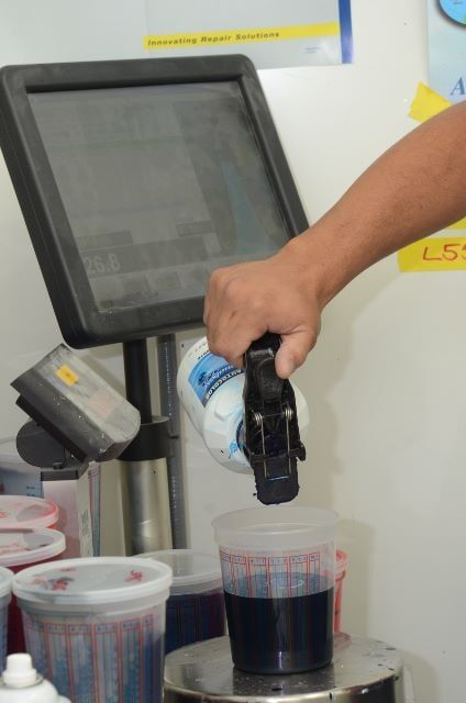 Man Pouring a Color Paint for Car Repair — Auto Repair in Braintree,, MA