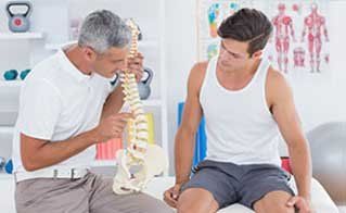 Doctor Showing Anatomical Spine  - Osteopathic Manipulative Medicine in Toms River, NJ
