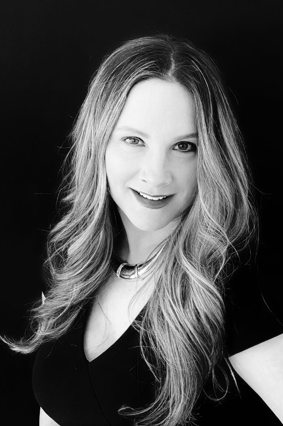 A black and white photo of a woman with long hair and a necklace.