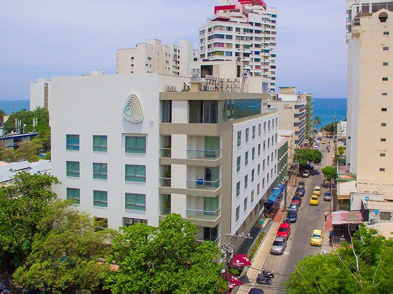 Un moderno edificio de hotel blanco y gris con vista al océano y a la calle en Cartagena, Colombia.