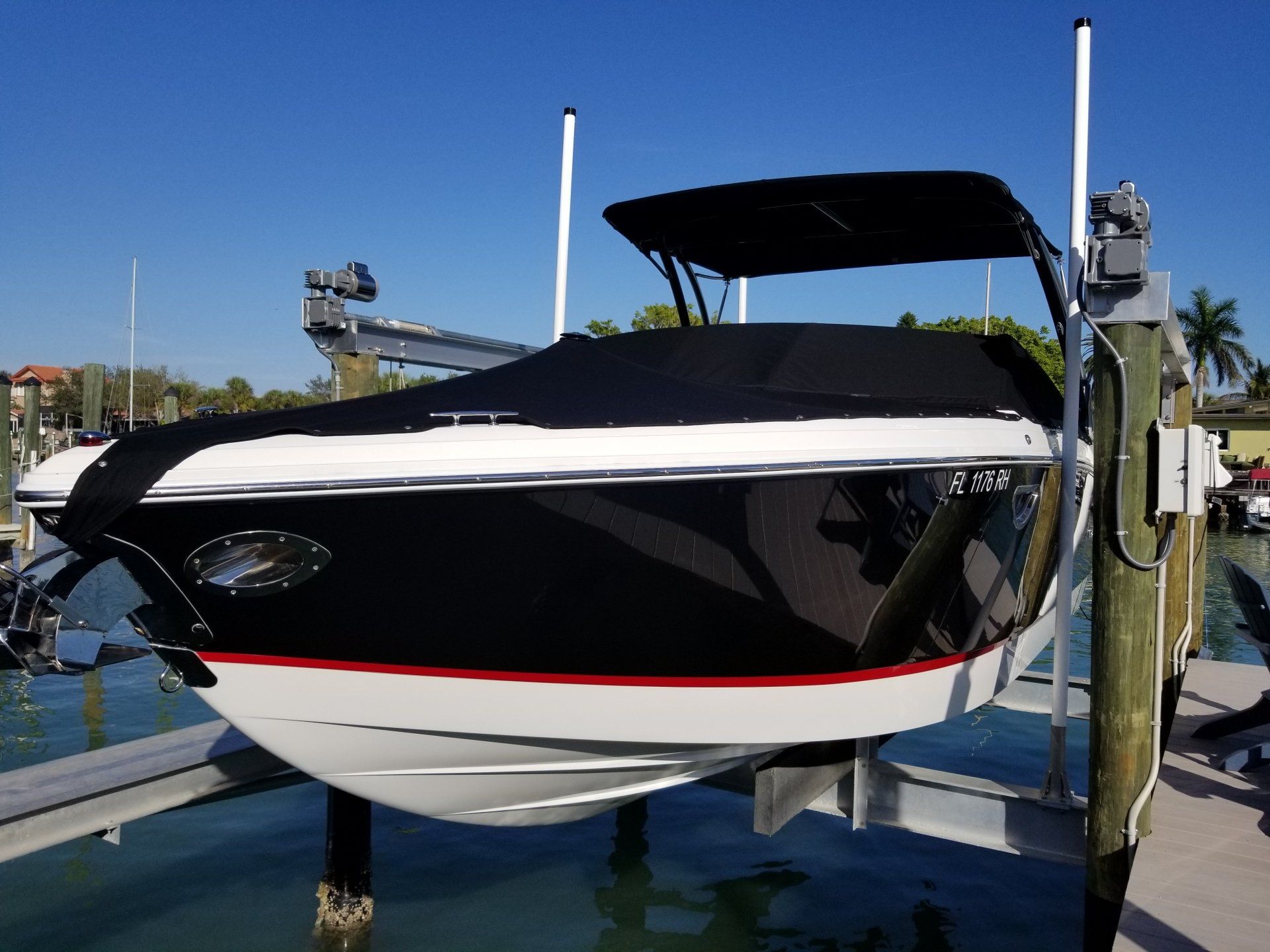 A black and white boat is sitting on a lift after a full boat detail.