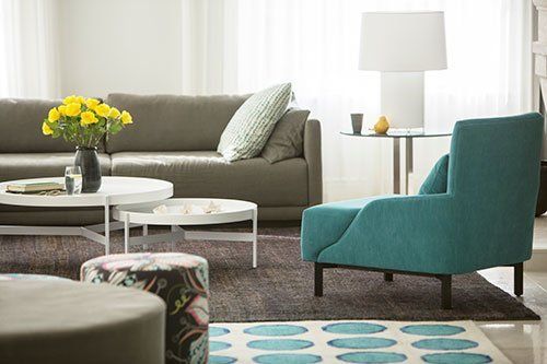 teal armchair and spotty rug