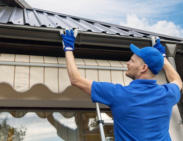 A Worker Installing A Residential Gutter — Hugo, MN — Titan Exteriors A Worker Installing A Residential Gutter — Hugo, MN — Titan Exteriors
