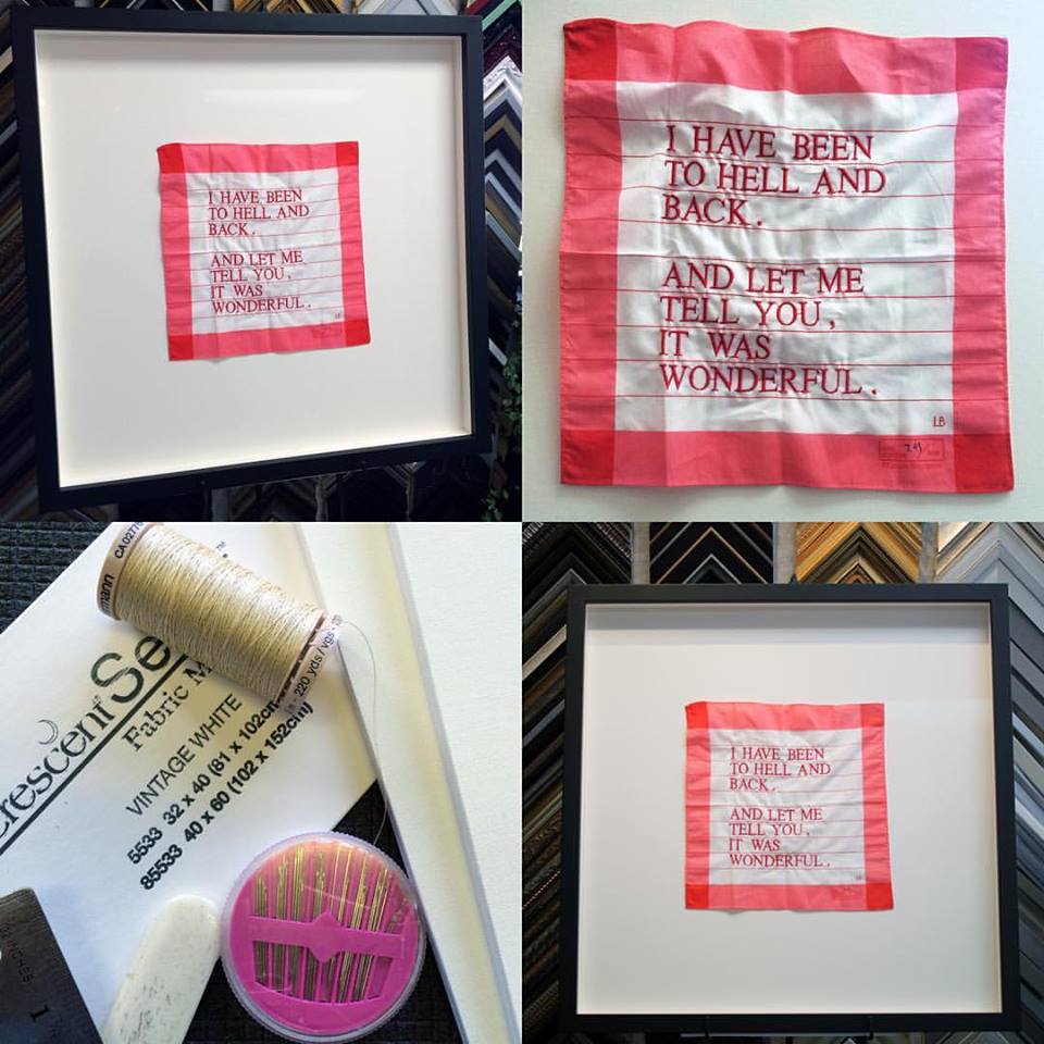 A framed textile artwork with the text,
