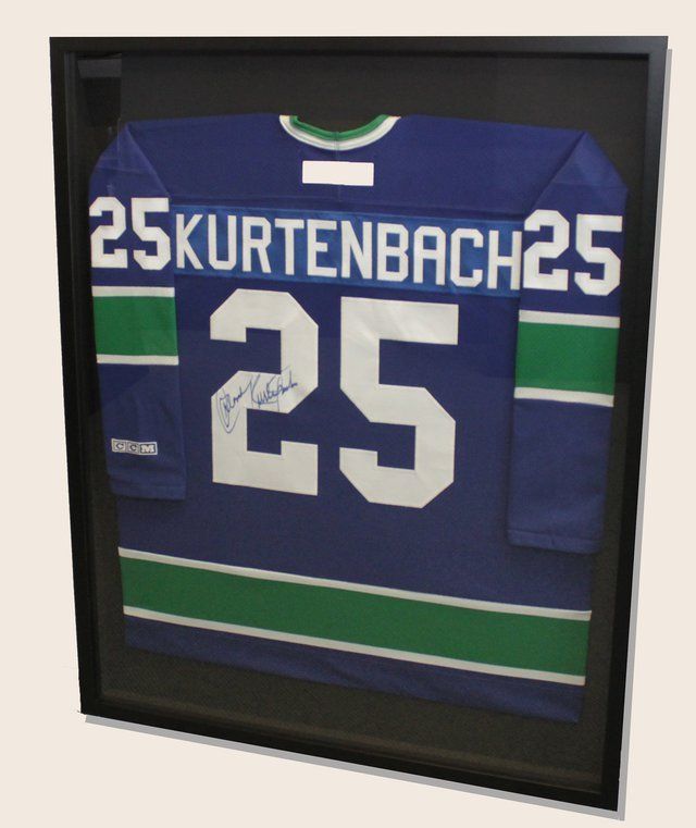 Framed blue Vancouver Canucks jersey with white number 25,
