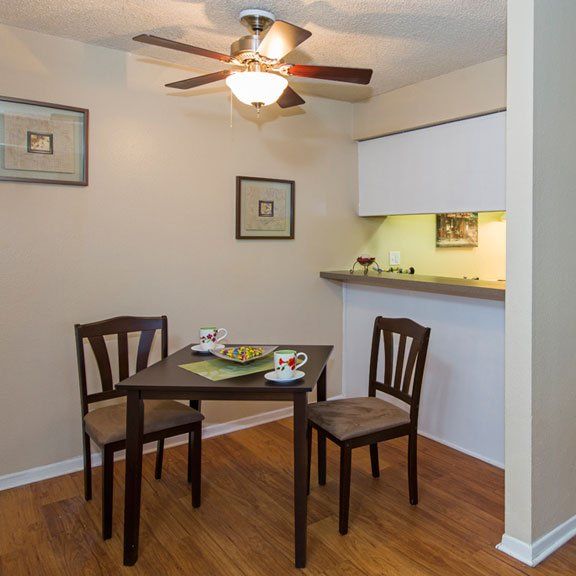 Dining area next to kitchen with ceiling fan