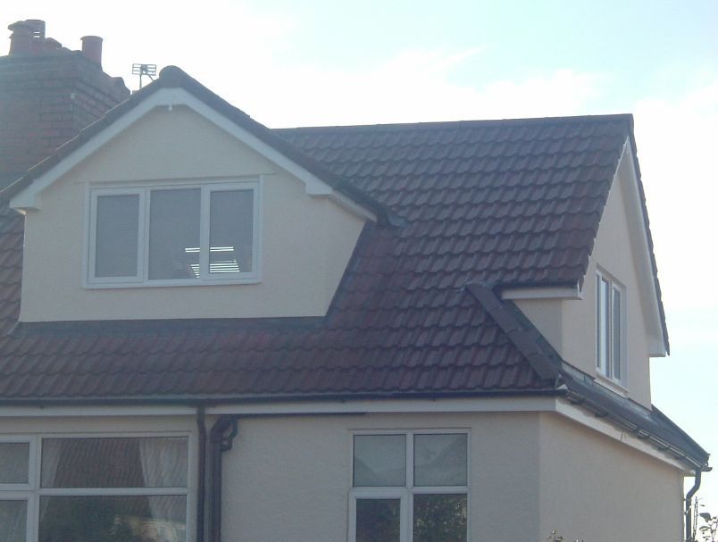 A white house with a brown roof and a window