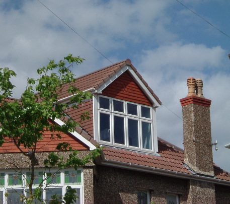 A house with a chimney and a window on the roof