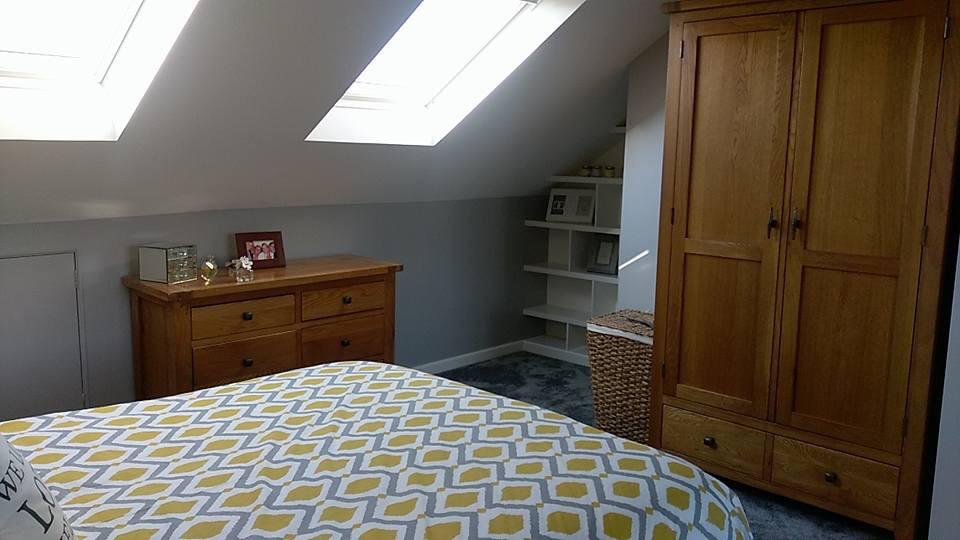 A bedroom with a bed , dresser , and wardrobe.