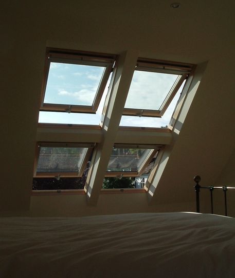 A bedroom with a lot of windows and a bed