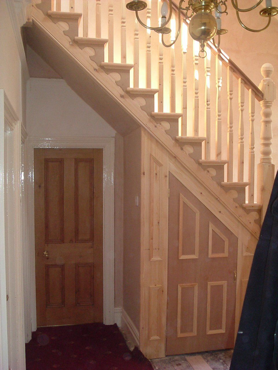 A wooden staircase with a door underneath it