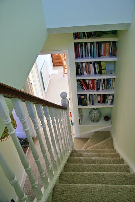 Stairs leading up to a bookshelf with books on it