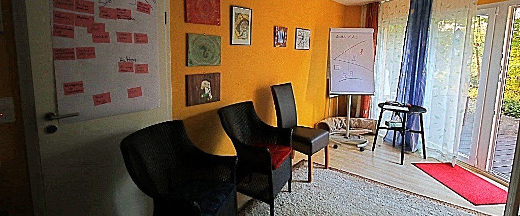 Ein Raum mit Stühlen und einer weißen Tafel an der Wand