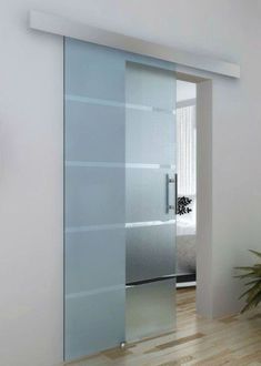Modern frosted glass sliding door with chrome handles in a minimalist room