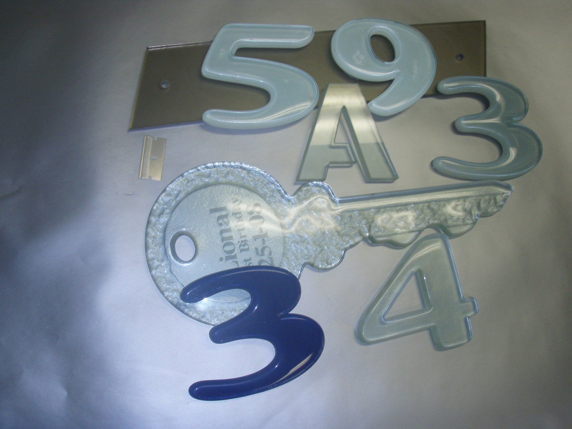 Silver and blue decorative numbers and a key mounted on a wall plaque