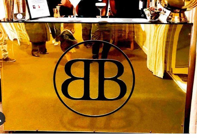 Gold-toned counter with a circular black “BB” logo in a restaurant or bar interior