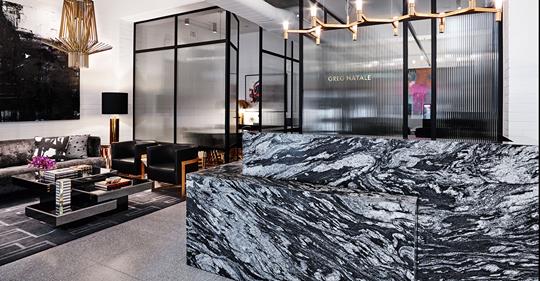 Modern hotel lobby with a large black-and-white marble reception desk and sleek glass partitions