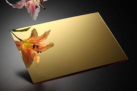 Gold mirrored plaque with orange flower reflection on a dark background