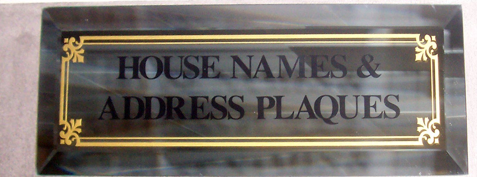 Black and gold sign reading “HOUSE NAMES & ADDRESS PLAQUES”