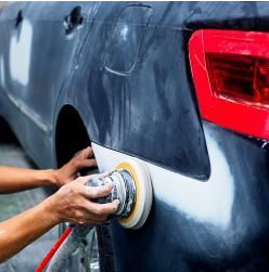 A person is polishing a car with a machine.