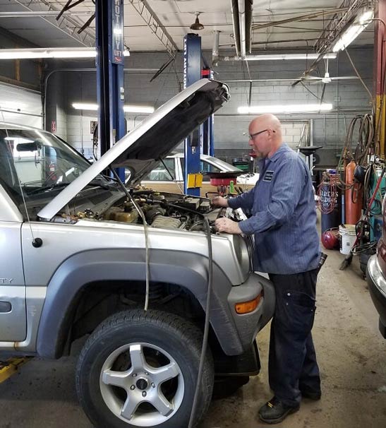 Mechanic Under Car — Engine Repair in Allen Park, MI Mechanic Under Car — Engine Repair in Allen Park, MI