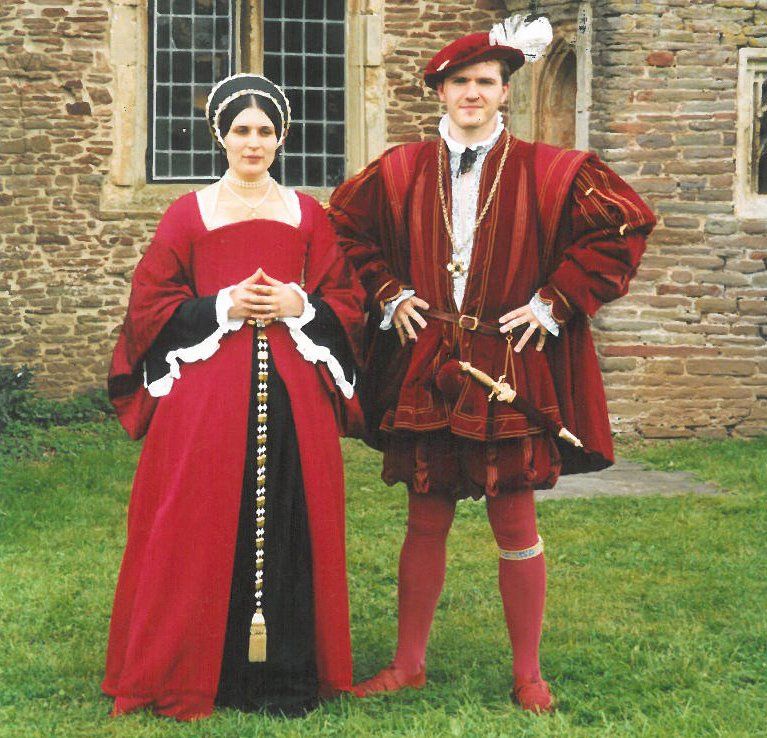 A man and a woman are dressed in Tudor costumes