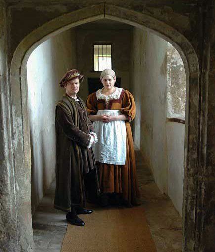 A Tudor man and a woman standing in a hallway.