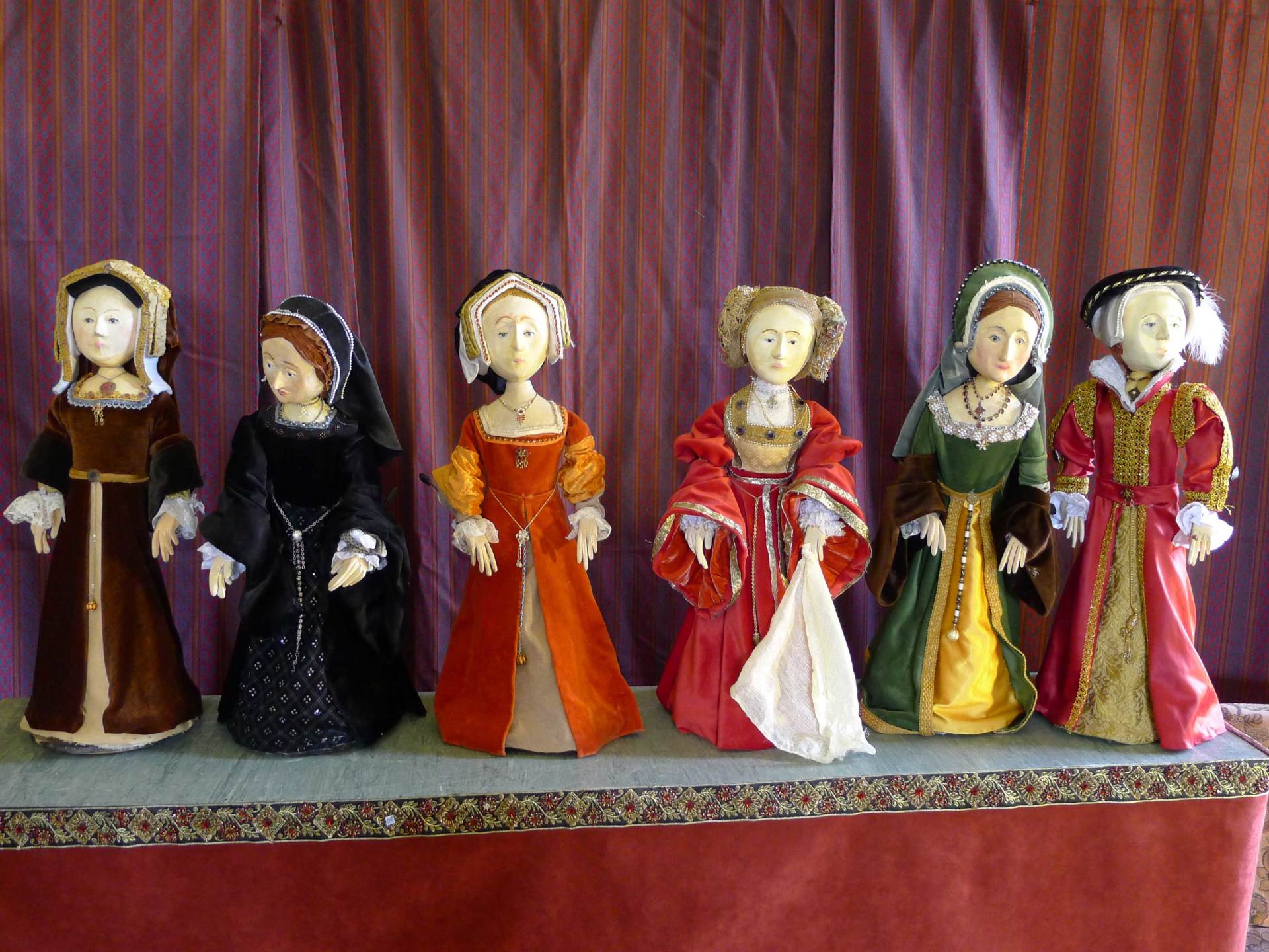 A group of tudor dolls are standing next to each other on a table.