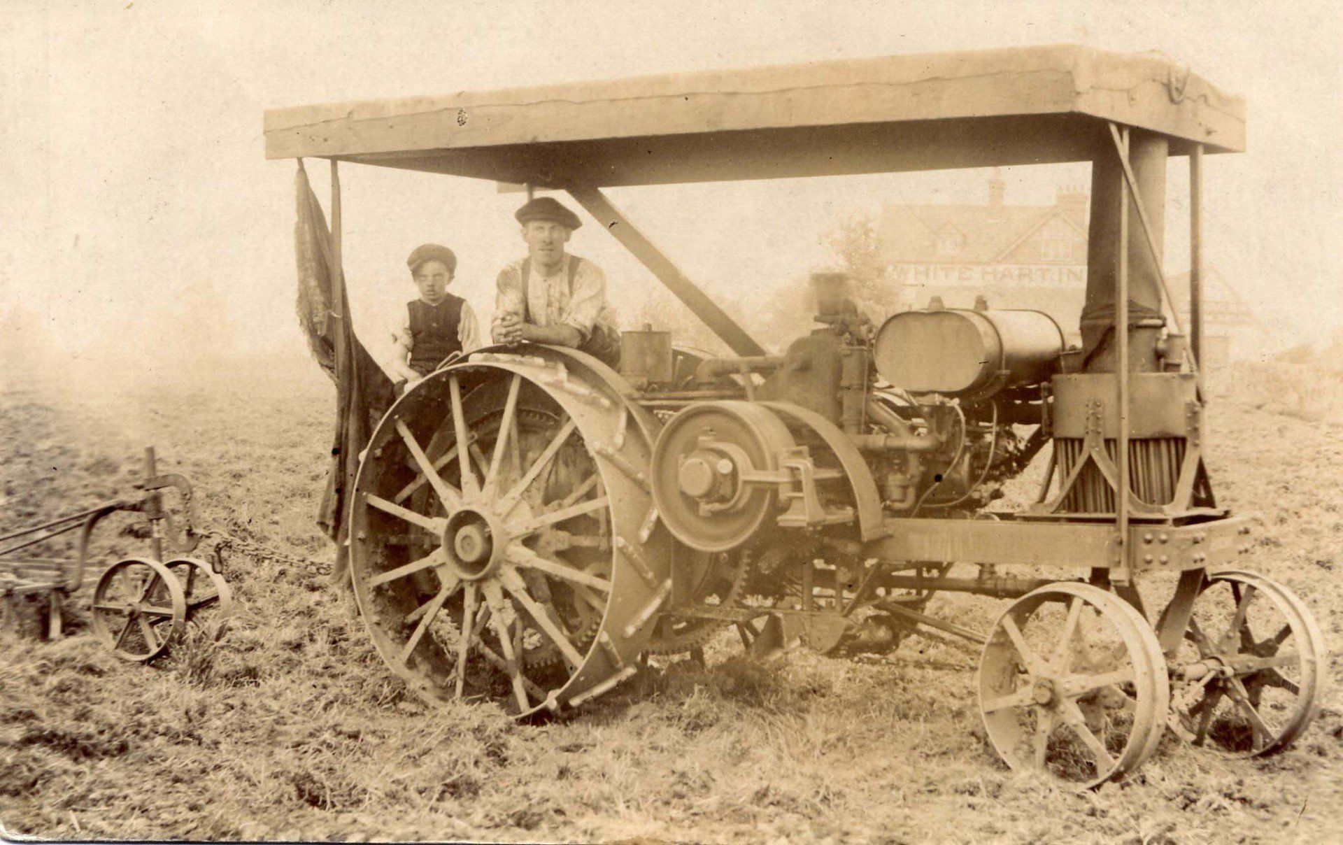 A black and white photo of an old tractor in a field at Acton Court
