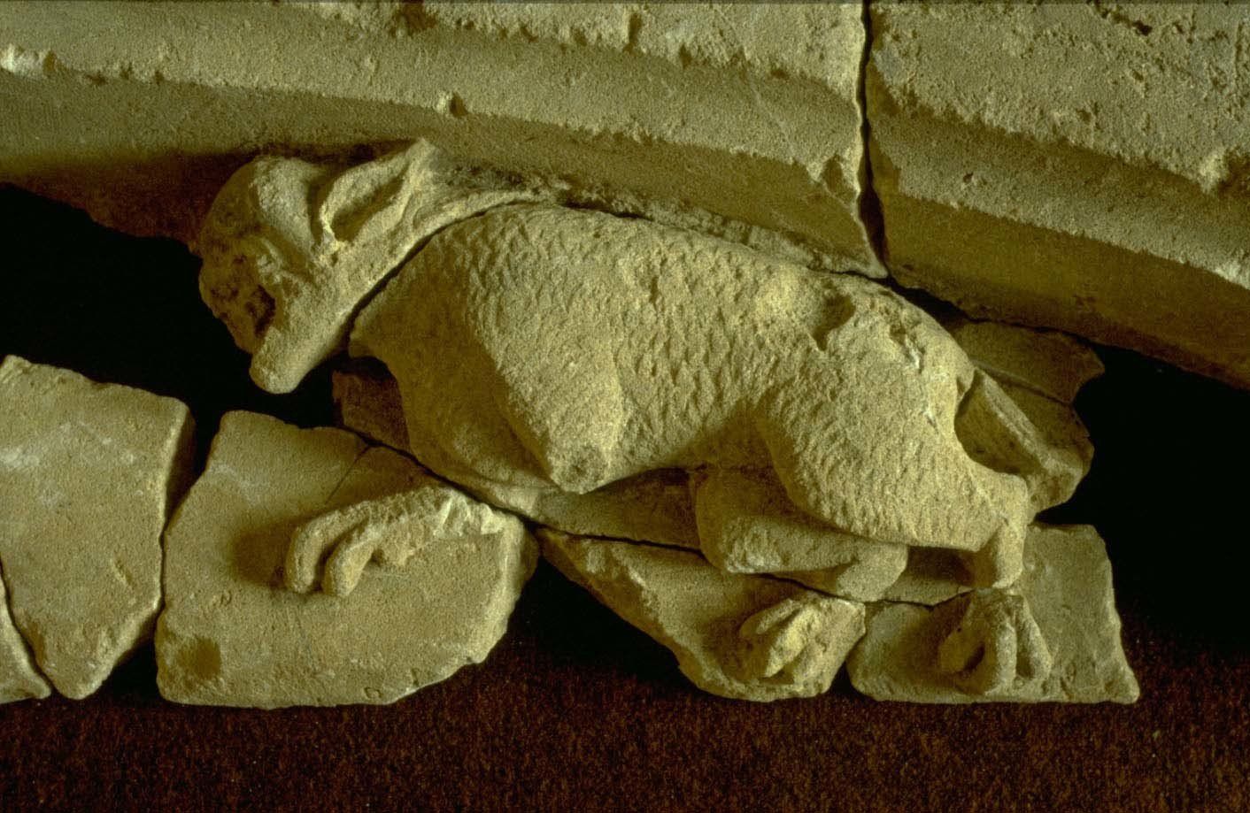 A statue of a wolf carved in stone.