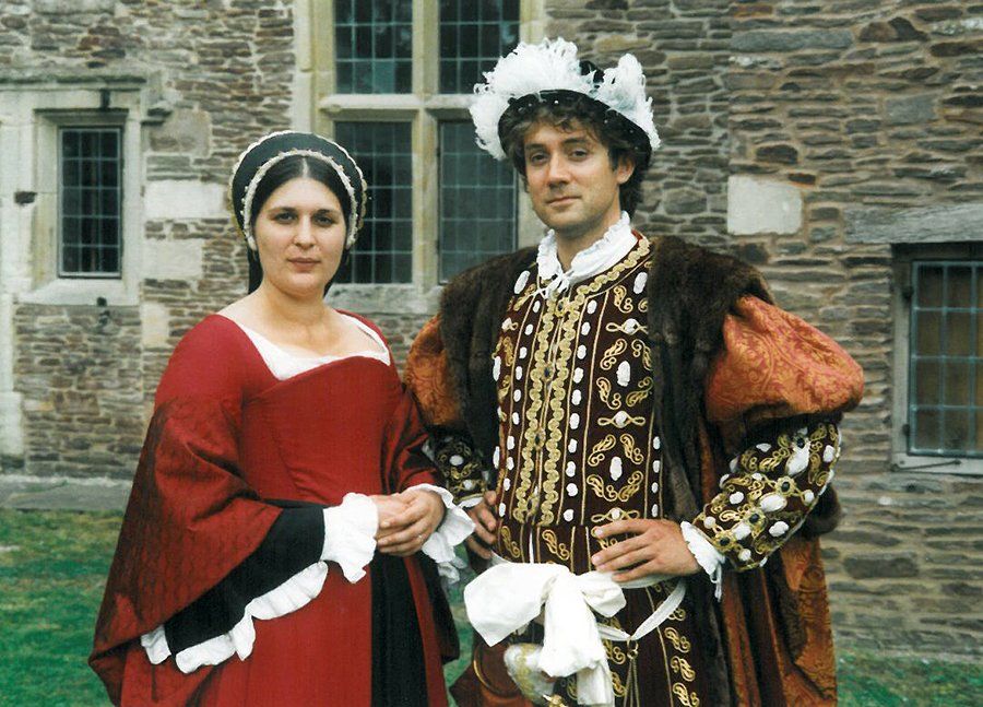 A man and a woman are dressed in Tudor costumes