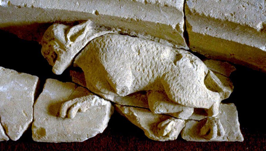 A statue of a wolf carved in stone.