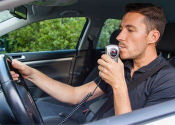 DUI Attorney — Man Blowing into Breathalyzer in Miamisburg, OH DUI Attorney — Man Blowing into Breathalyzer in Miamisburg, OH