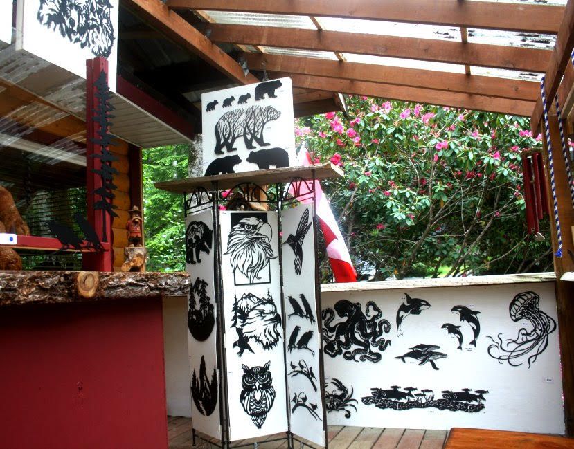 Black-and-white animal murals on a column and wall under a wooden pergola in a garden patio
