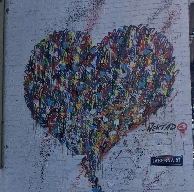 Eine Backsteinmauer mit einem aufgemalten Herzen und einem Schild mit der Aufschrift „Taberna St.“