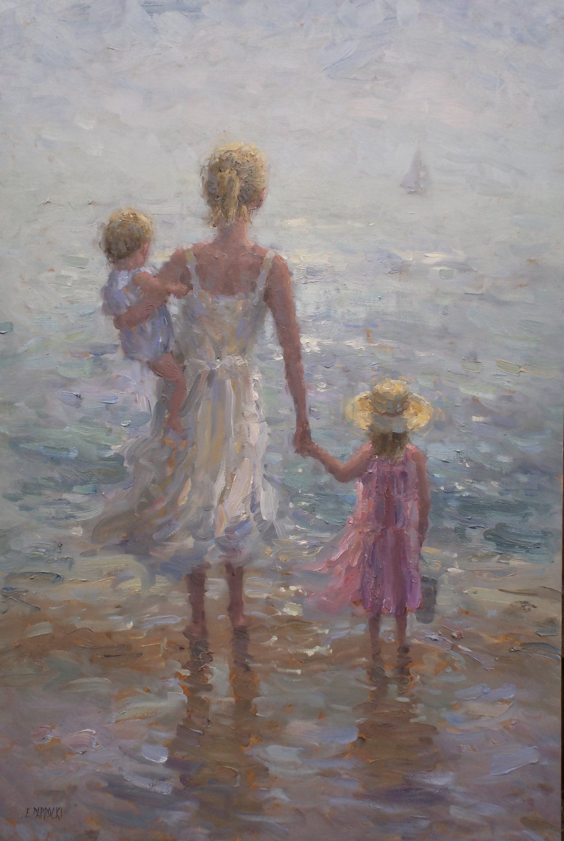 A woman is holding two children 's hands while walking on the beach.