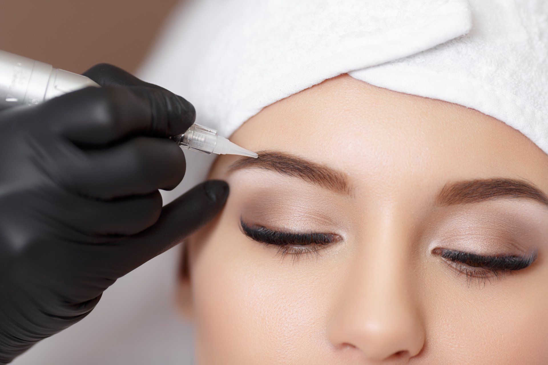 Eine Frau lässt sich Permanent Make-up auf die Augenbrauen machen.