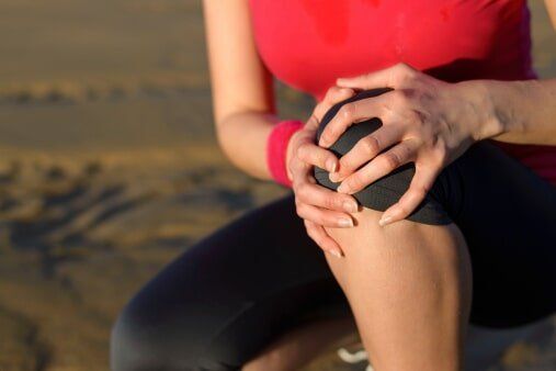 Woman holding her knee — Jersey City, NJ — Pain and Disability Institute