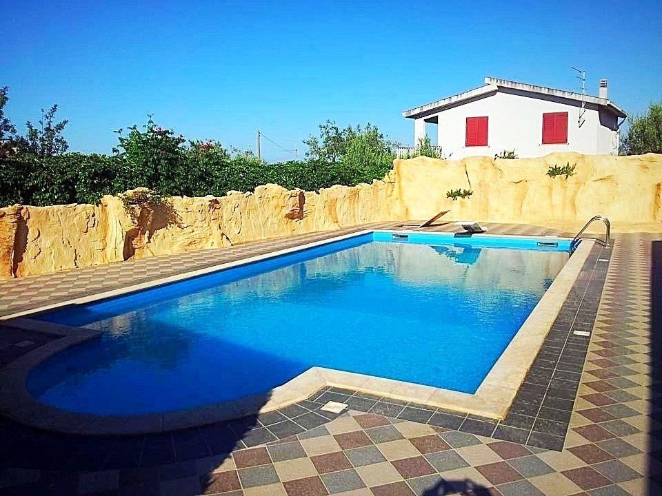 piscina interrata con piastrelle tutto intorno