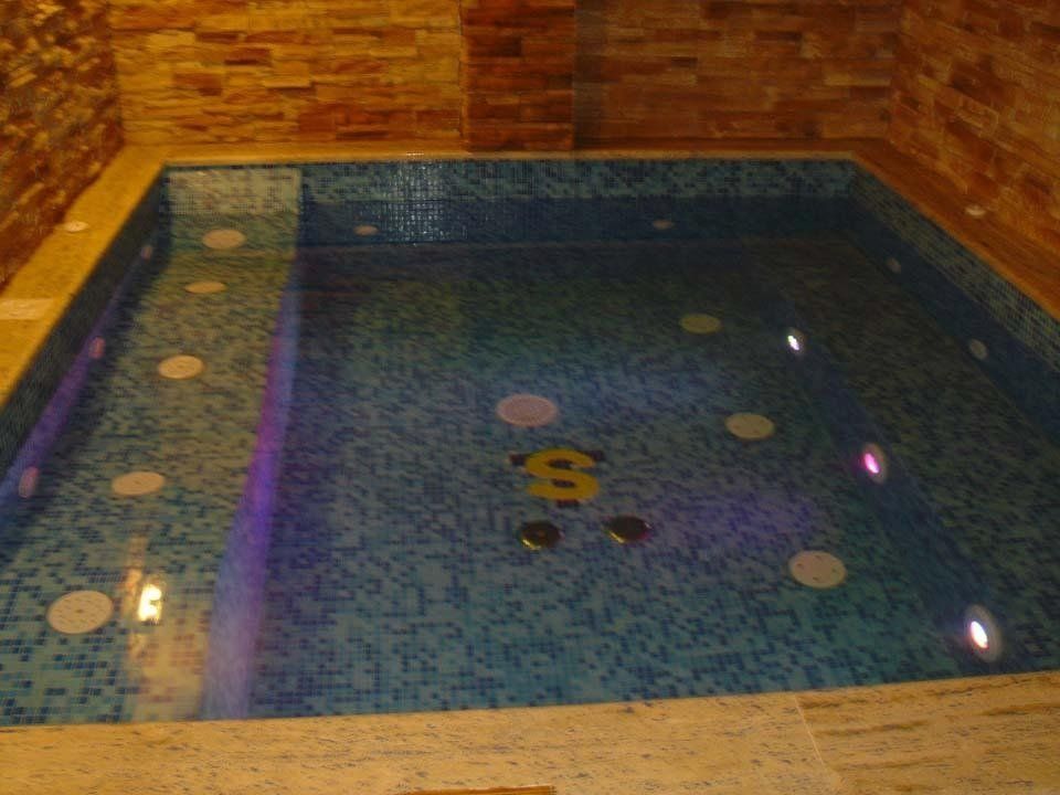 piscina interna con mosaico e luci