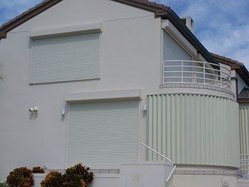 Hurricane Shutters Ormond Beach FL — White House with Storm Shutter in Ormond Beach, FL Hurricane Shutters Ormond Beach FL — White House with Storm Shutter in Ormond Beach, FL