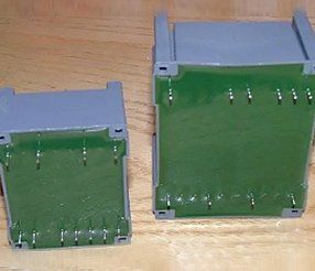 Due componenti elettronici rettangolari grigi e verdi con pin sporgenti.