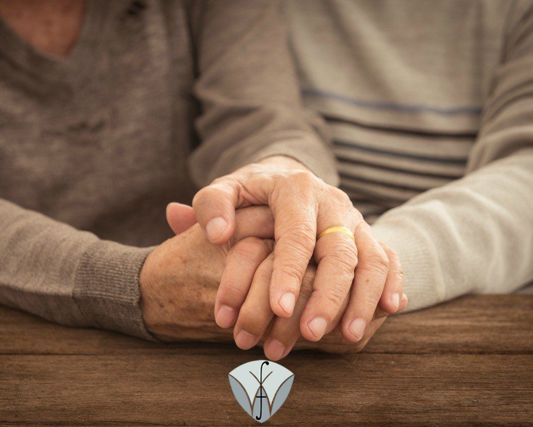 A man and woman are holding hands while sitting at a table.