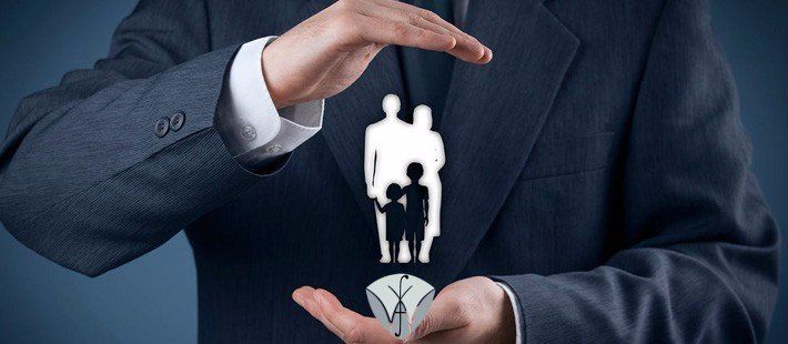 A man in a suit is holding a picture of a family in his hands.