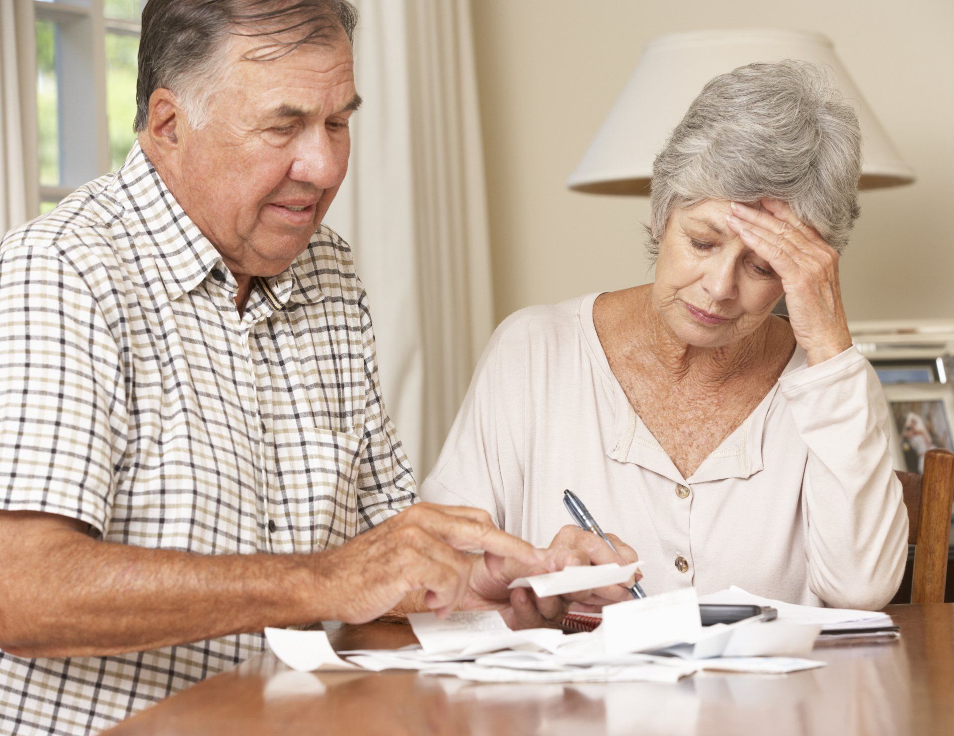 A man and a woman are sitting at a table looking at papers.