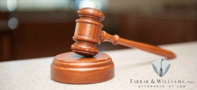 A wooden judge 's gavel is sitting on a counter.