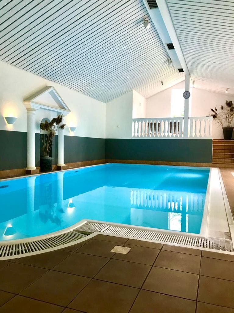 Ein großes Hallenbad mit Balkon und Treppe
